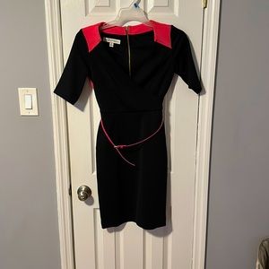 Black and hot pink tightly fitting knee length dress with waist belt.